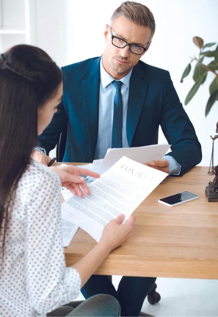 male-lawyer-looking-at-client-reading-contract-QGN6KEA